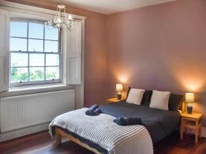 a bedroom with a bed and a window at North Cottage in Lowestoft