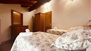 a bedroom with two beds with white comforters at apartamentos lleguera 1 in Llanes