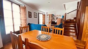 a dining room and kitchen with a wooden table and chairs at apartamentos lleguera 1 in Llanes