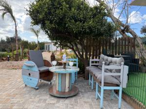 a patio with chairs and a table and a tree at Casa Oliveira in Silves