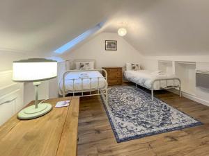 a room with two twin beds and a lamp at 6 Mill Road in Okehampton +5 photos