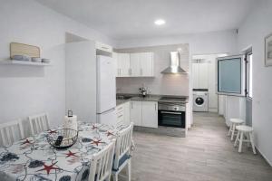 a kitchen with a table and a kitchen with white cabinets at Casa Ángela in La Restinga