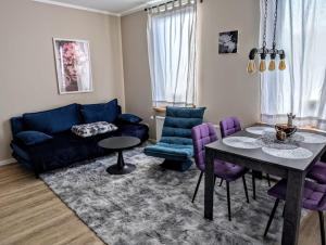 a living room with a blue couch and purple chairs at Jessis Harz Appartements in Sankt Andreasberg