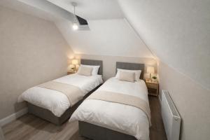two beds in a attic bedroom with two lamps at 5 Bedroom Home Monaghan Town in Monaghan