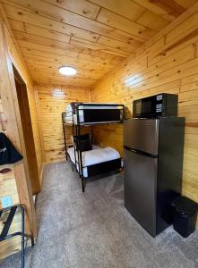 a cabin with a bunk bed and a refrigerator at A Night In Northfield in Hixton