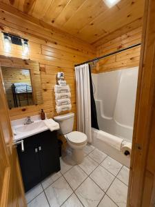 a wooden bathroom with a toilet and a sink at A Night In Northfield in Hixton