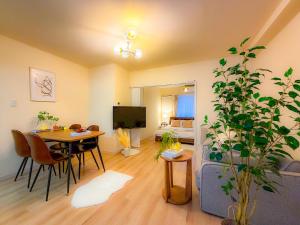 a living room with a dining table and a living room with at Odori 601 Max 7 guests Odori Park 4m Tram 2m Subway 4m in Ōdōri