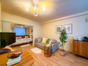 a living room with a couch and a tv at Odori 601 Max 7 guests Odori Park 4m Tram 2m Subway 4m in Ōdōri
