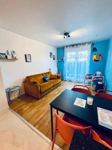 a living room with a table and a couch at Be My Guest - Proche Disneyland Paris in Quincy-Voisins