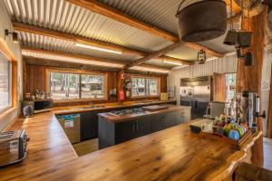 a large kitchen with wooden floors and a wooden ceiling at Wallaroo Outback Retreat - Glamping Tents Carnarvon Gorge in Hutton