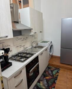 a kitchen with a stove and a sink and a refrigerator at SuiteMazzini in Lamezia Terme