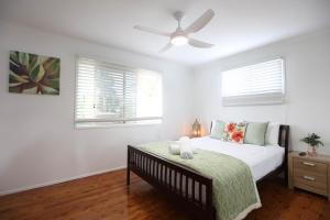 a bedroom with a bed and a ceiling fan at Enchanted Garden, 3 bedrooms in Sandstone Point