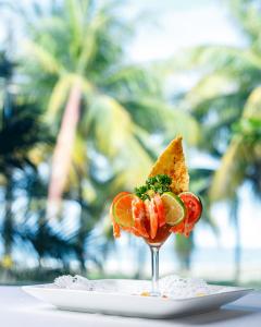 a glass with a piece of food on a plate at Telamar Resort in Tela