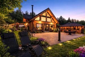 a log cabin with two chairs in the yard at Căsuța Melimi cu piscină încălzită, ciubăr și saună in Râșca