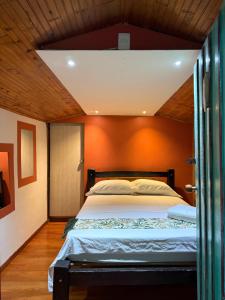 a bedroom with a bed with an orange wall at Cabañas el Portal in Santa Rosa de Cabal +78 photos