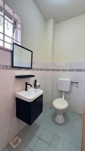 a bathroom with a toilet and a sink and a tv at De'Bestari Homestay in Ipoh