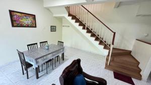 a living room with a table and a staircase at De'Bestari Homestay in Ipoh +7 photos