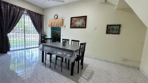 a dining room with a table and some chairs at De'Bestari Homestay in Ipoh