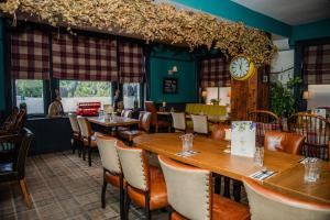 a restaurant with tables and chairs and a clock at Grantham Arms in Boroughbridge +35 photos
