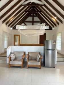 a kitchen with two chairs and a table and a refrigerator at Vila Del Mare Oceanfront Villas in Port Vila