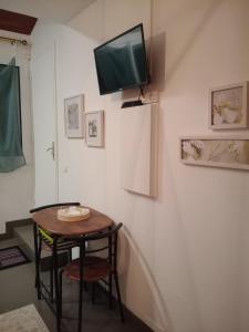 a room with a table and a television on a wall at Studio Barbotan-les-Thermes in Cazaubon