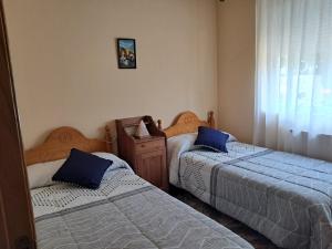 a bedroom with two beds with blue pillows at El Parangón in Herradón de Pinares