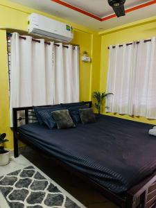 a bed in a room with yellow walls and white curtains at House Of Green Flag VIP ROAD Baguiati Kolkata in kolkata +15 photos