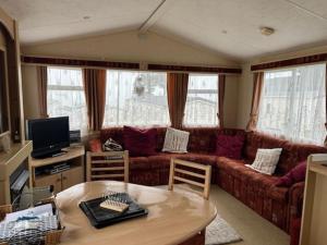 a living room with a couch and a table at Sandhills Holiday Park Astounding Sea Views in Bembridge