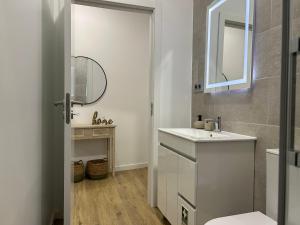 a bathroom with a white sink and a mirror at Frades house in Câmara de Lobos