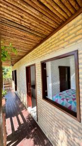 a mirror on the side of a house with a bed at Mango Village Paracuru CE in Paracuru