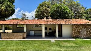 a house with a stone wall and a patio at Mango Village Paracuru CE in Paracuru