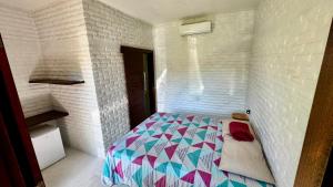 a small bedroom with a bed in a wall at Mango Village Paracuru CE in Paracuru +11 photos