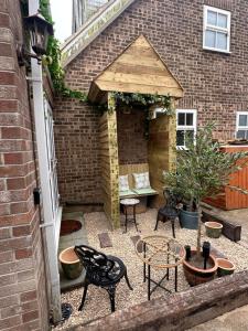 a patio with chairs and tables and a building at Garden Galley Nook in Sproatley