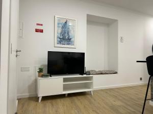 a living room with a tv on a white wall at Frades house in Câmara de Lobos