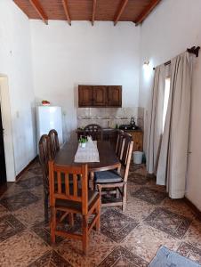 a kitchen with a table and chairs and a refrigerator at Los Patitos Bungalows in Gualeguaychú