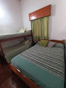 a bedroom with a bed and a bunk bed at Los Patitos Bungalows in Gualeguaychú +6 photos