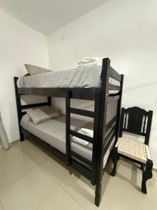 a black bunk bed with a chair in a room at Tres Soles 2 in Salsipuedes +16 photos