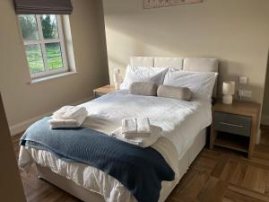 a bedroom with a large bed with towels on it at Dannys Haven in Ballagh Cross Roads