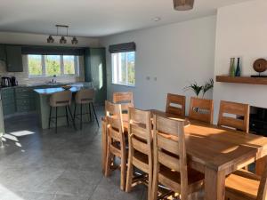 a kitchen and dining room with a wooden table and chairs at Dannys Haven in Ballagh Cross Roads +9 photos