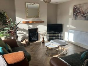 a living room with a couch and a table and a television at Dannys Haven in Ballagh Cross Roads
