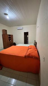 a bedroom with a large orange bed in a room at Casa Aguiar in Santarém