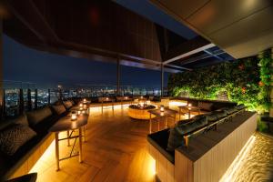 a rooftop bar with tables and a view of the city at HOTEL METROPOLITAN OIMACHI TRACKS Tokyo in Tokyo