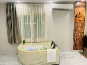 a bath tub in a room with a window at Golden mask pyramids inn in Cairo +62 photos