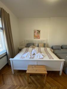 a white bed in a room with a couch at Mona Lisa Apartment in Bratislava