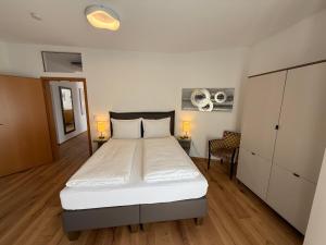 a bedroom with a large bed with white sheets at Residence Loft in Friedrichshafen