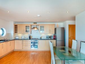 a kitchen with a glass table and a refrigerator at 10 Horizons in Newquay