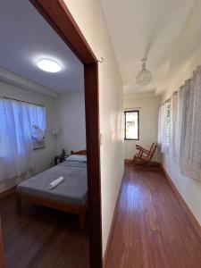 a bedroom with a bed and a wooden floor at The RM Homestay in Baclayon