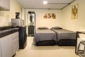 a kitchen with two beds in a room at Studio VII - Completo -Centro de Jundiaí in Jundiaí