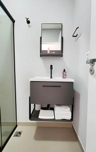 a bathroom with a sink and a mirror at Studio VII - Completo -Centro de Jundiaí in Jundiaí
