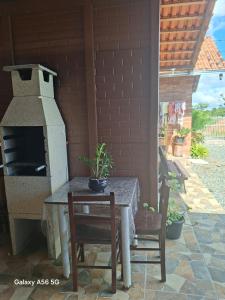 a patio with a table and an outdoor oven at Pousada do vô Bi 02 in São Francisco do Sul